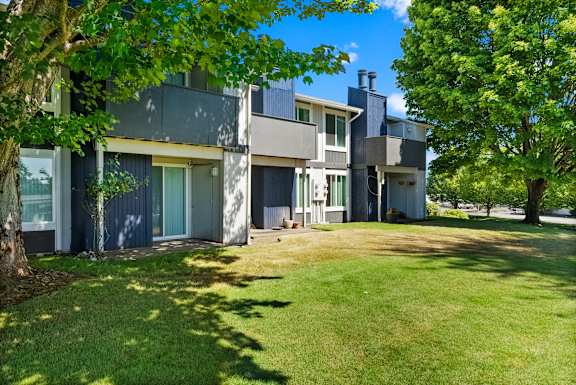A modern house with a green lawn in front.