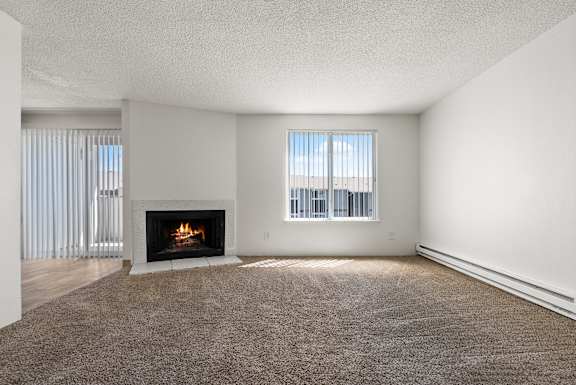 A living room with a fireplace and a carpet.