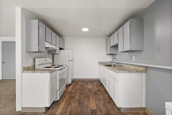 A kitchen with white appliances and cabinets.