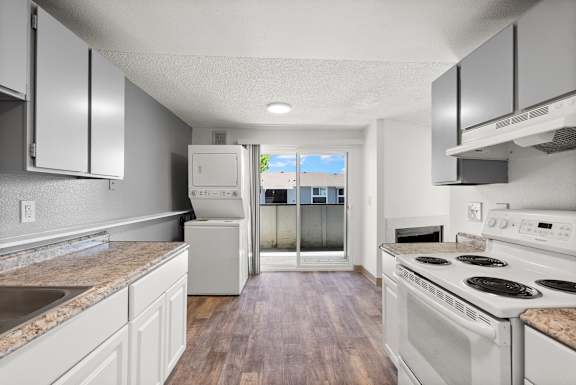 A kitchen with white appliances and wooden floors.