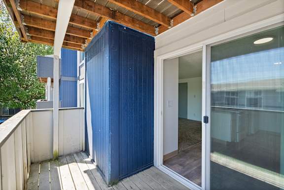 A blue container is attached to a white building.