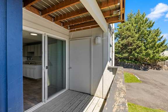 A modern house with a wooden deck and glass doors.