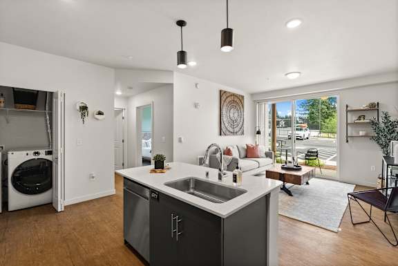 A modern kitchen with a large island and a view of the backyard.
