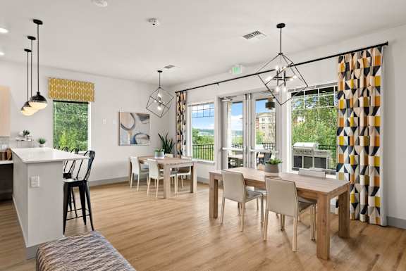 A modern dining room with a white kitchen island and a dining table with chairs.