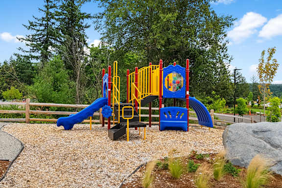 A playground with a blue slide and yellow and red play structure.