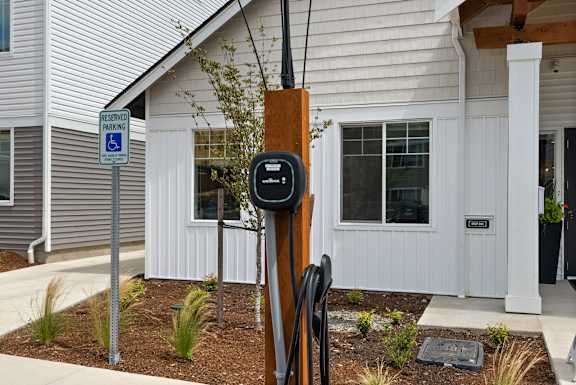 A parking meter is in front of a house with a sign that says "Reserved Parking".