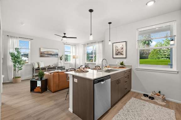 A modern kitchen with a large island and a dining area.