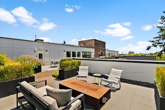 A patio with a table and chairs overlooking a building.
