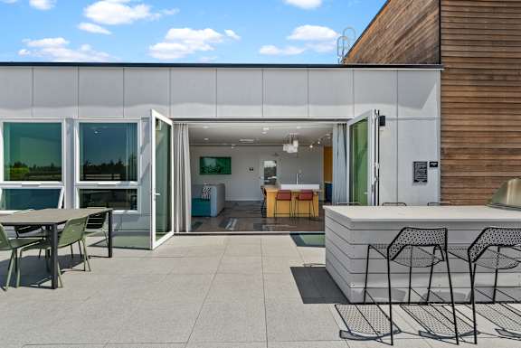 A modern patio area with a table and chairs.