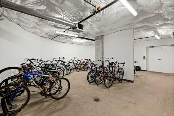 A room full of bicycles is covered with a white plastic sheet.