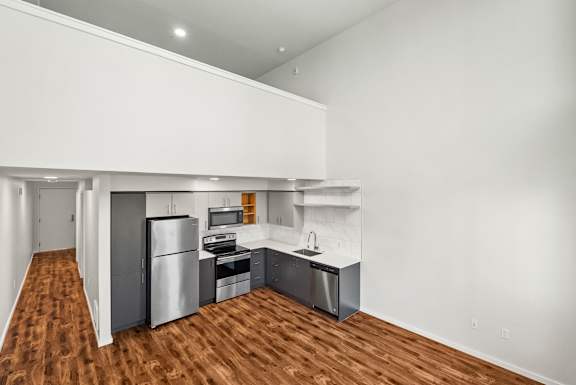 A kitchen with a refrigerator, sink, and stove.