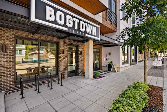 The image shows the exterior of a building named Boetown Flats with a brick facade and glass doors.