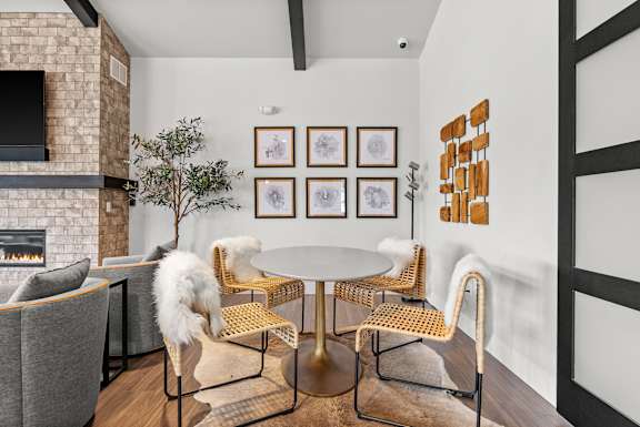 A living room with a fireplace and a white fluffy dog.