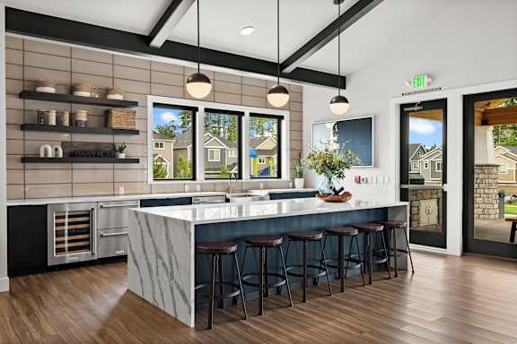 A kitchen with a marble counter top and bar stools.