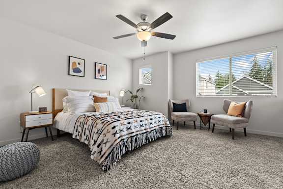 A bedroom with a large bed and a ceiling fan.