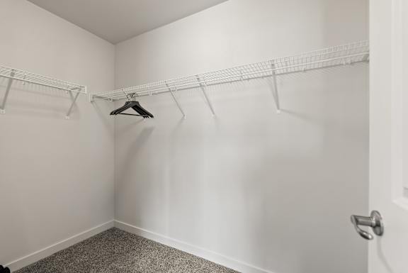 A white closet with a hanger and a door.