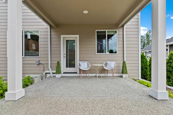 A house with a grey front porch and white columns.
