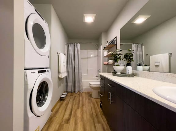 A small bathroom with a washing machine built into the wall.