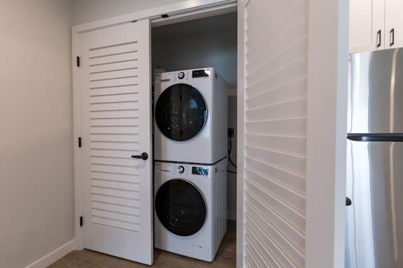 A white cabinet with a washing machine and dryer inside.