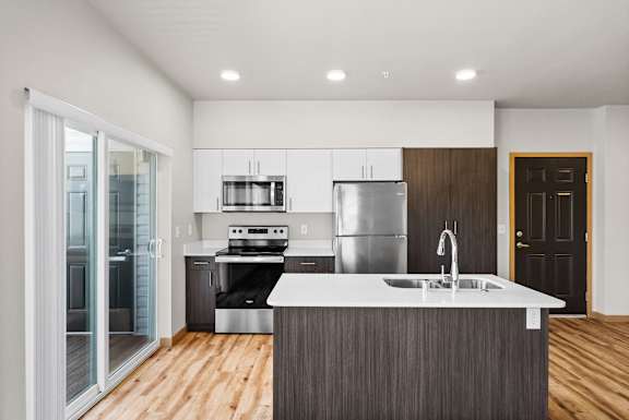 an empty kitchen with a sink and a refrigerator