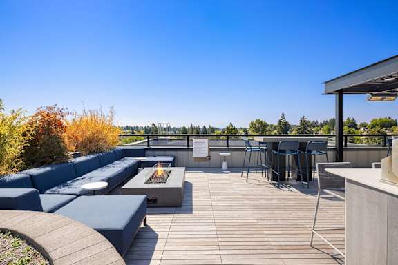 A patio with a fire pit and seating area.