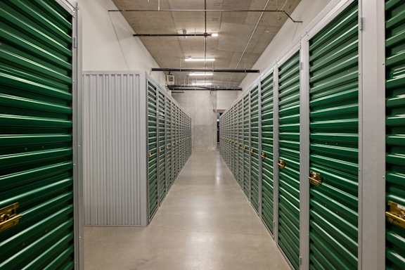 A long hallway with green storage units on both sides.
