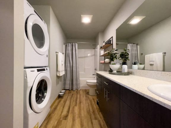 a bathroom with a washing machine and a toilet at Pottery Creek Apartments, Port Orchard