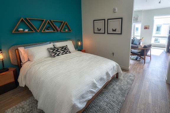 A bedroom with a large bed and a blue wall.