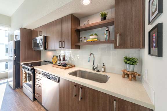 A modern kitchen with wooden cabinets and stainless steel appliances.