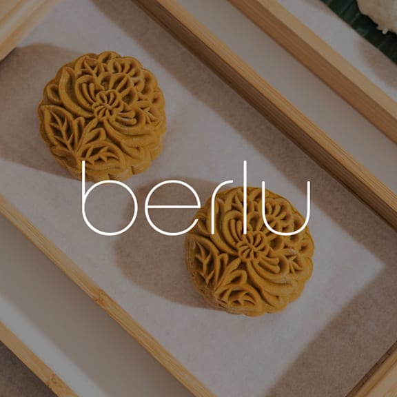 Two round mooncakes with the word "berlu" written on them.