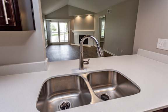 A modern kitchen with a double sink and a faucet.