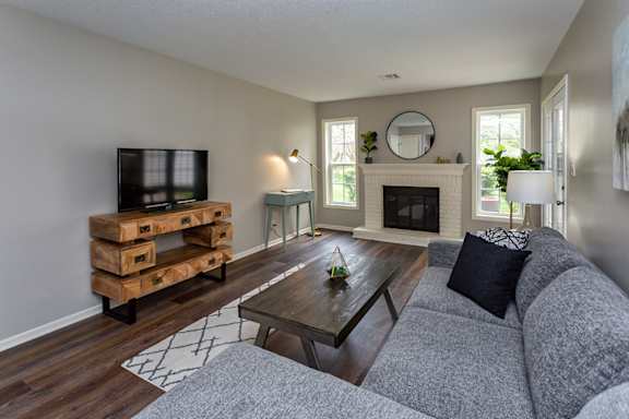 A living room with a grey couch and a wooden coffee table.