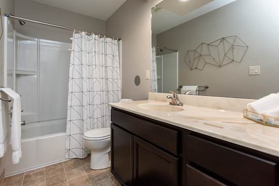 A bathroom with a toilet, sink, and shower.