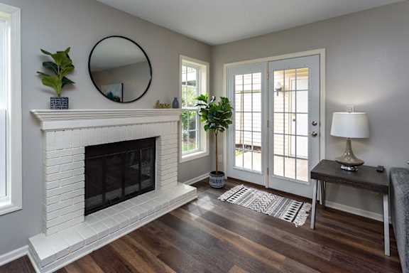 A living room with a fireplace and a mirror on the wall.