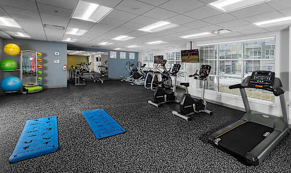 A gym with treadmills, exercise balls, and other equipment.