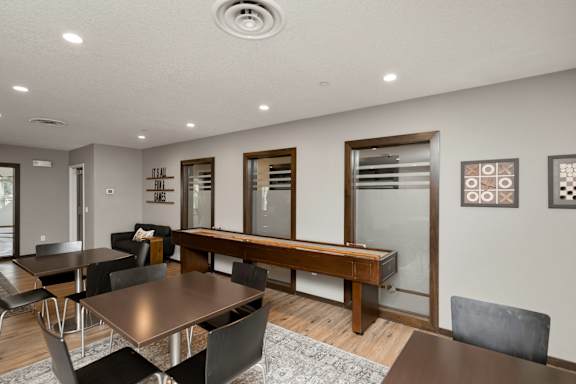 A modern dining room with a wooden table and chairs.