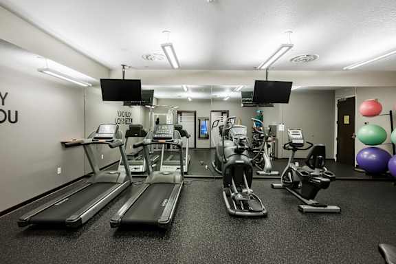 A gym with treadmills, exercise bikes, and a mirror.