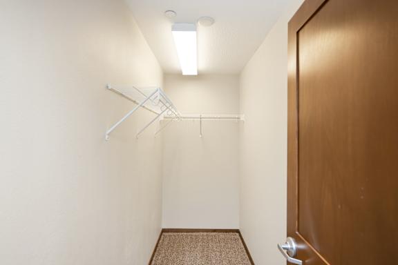 A hallway with a brown door and a white wall.