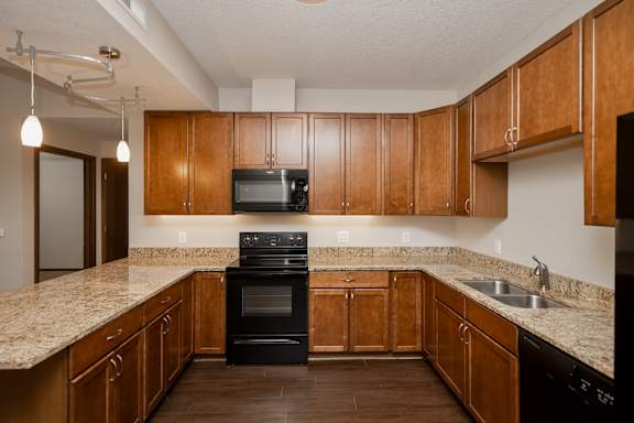 A kitchen with wooden cabinets and black appliances.
