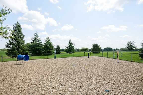A playground with a blue barrel and yellow sand.