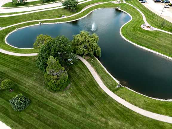 A fountain in the middle of a lake surrounded by trees.