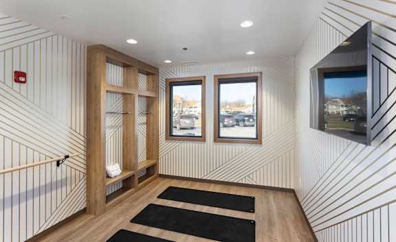 A hallway with a black and white striped wallpaper and a wooden floor.