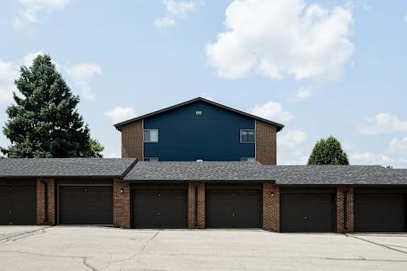 A blue building with a black roof and a garage door.