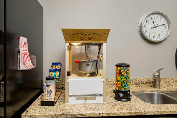 A small candy-coated candy machine sits on a kitchen counter.