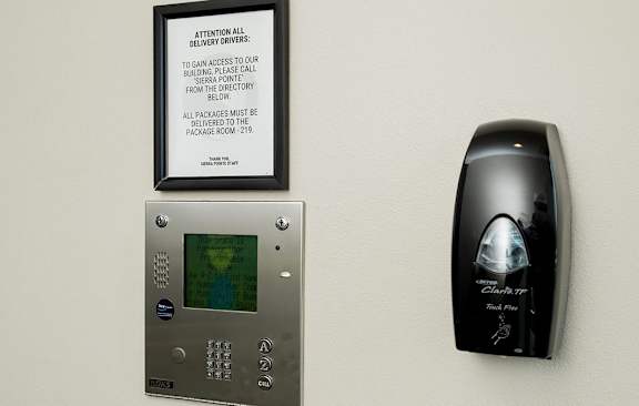 A keypad with a screen and a keypad reader are on the wall.