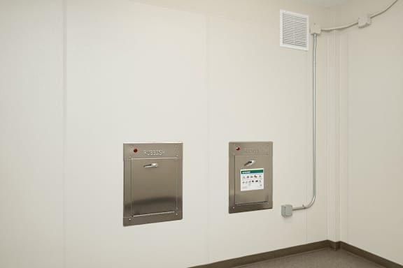 Two metal boxes on a wall with one having a calendar on it.