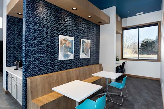 A kitchen with a table and chairs.