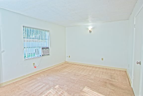 the living room and dining room of an empty house with a window
