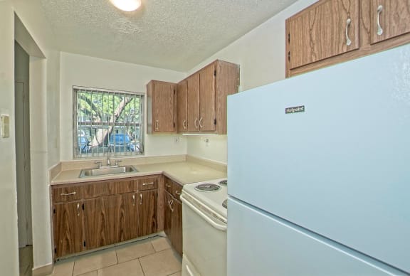 a kitchen with white appliances and wooden cabinets