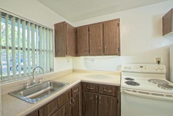 a kitchen with wooden cabinets and a sink and a stove